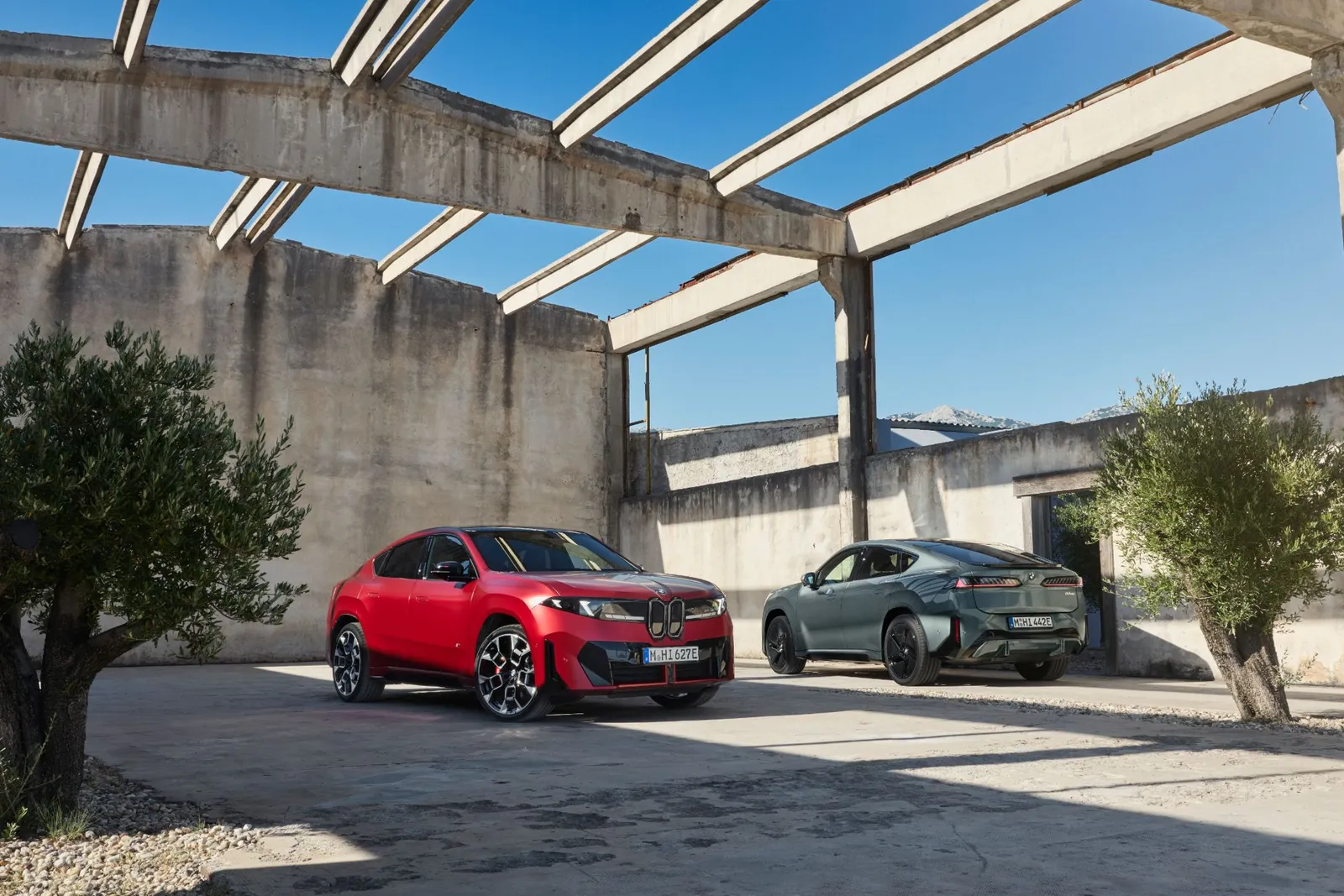 BMW iX4 vermelho e verde em galpão de concreto