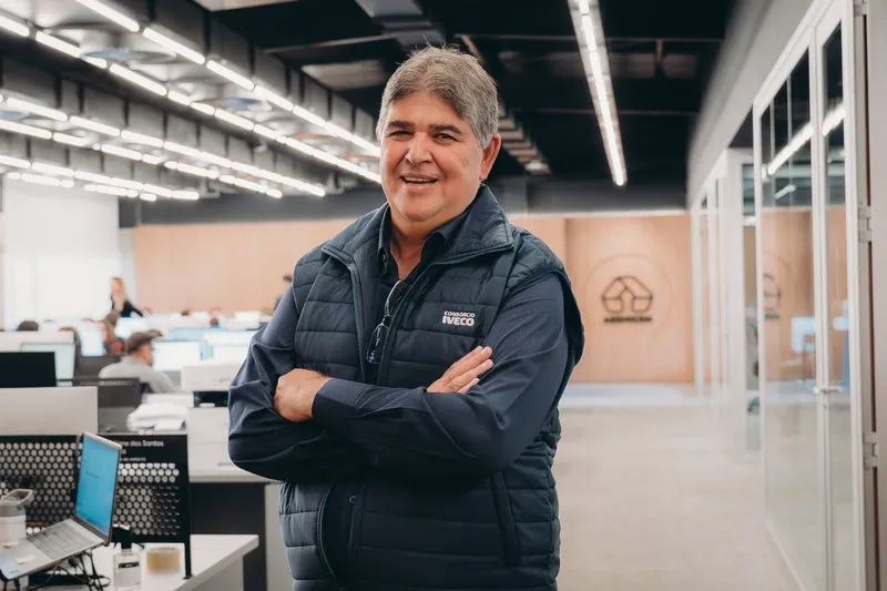 Mauro Andrade, gerente comercial do Consórcio IVECO, de braços cruzados em um escritório