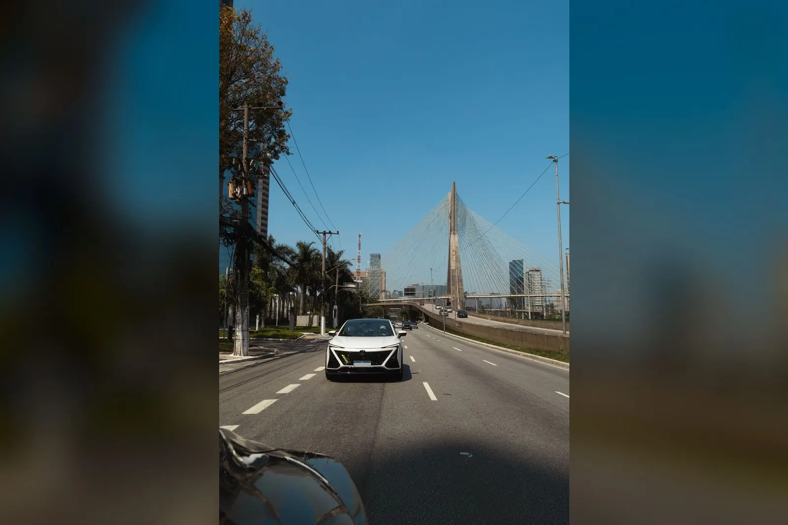UNI-T branco à frente do comboio, com a Ponte Estaiada ao fundo