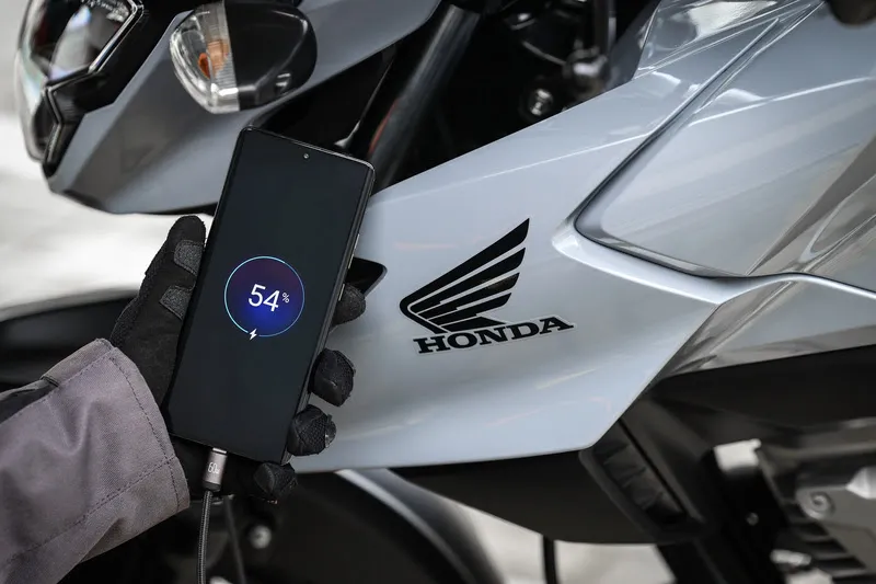 Celular carregando na entrada USB-C da moto