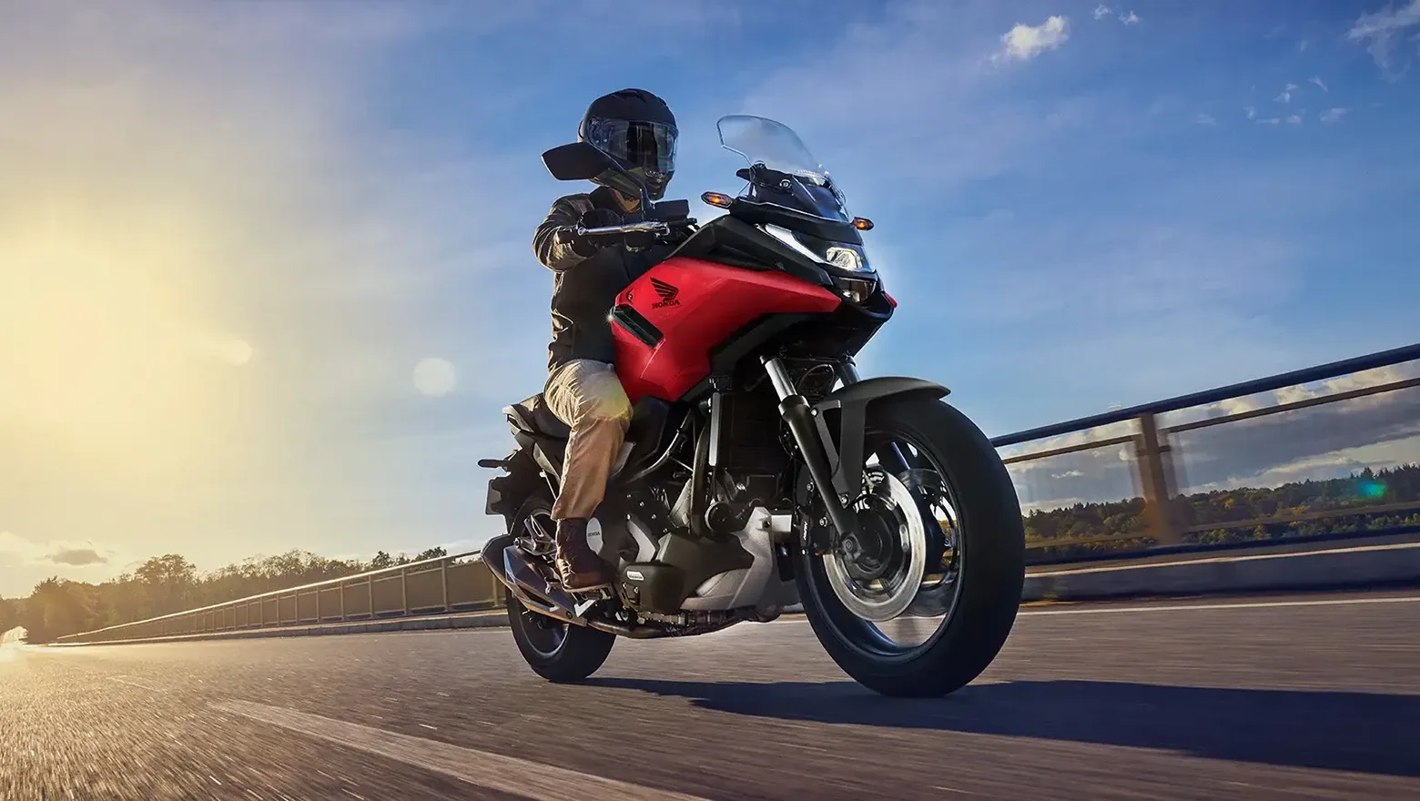 Honda NC750X vermelha em movimento numa ponte