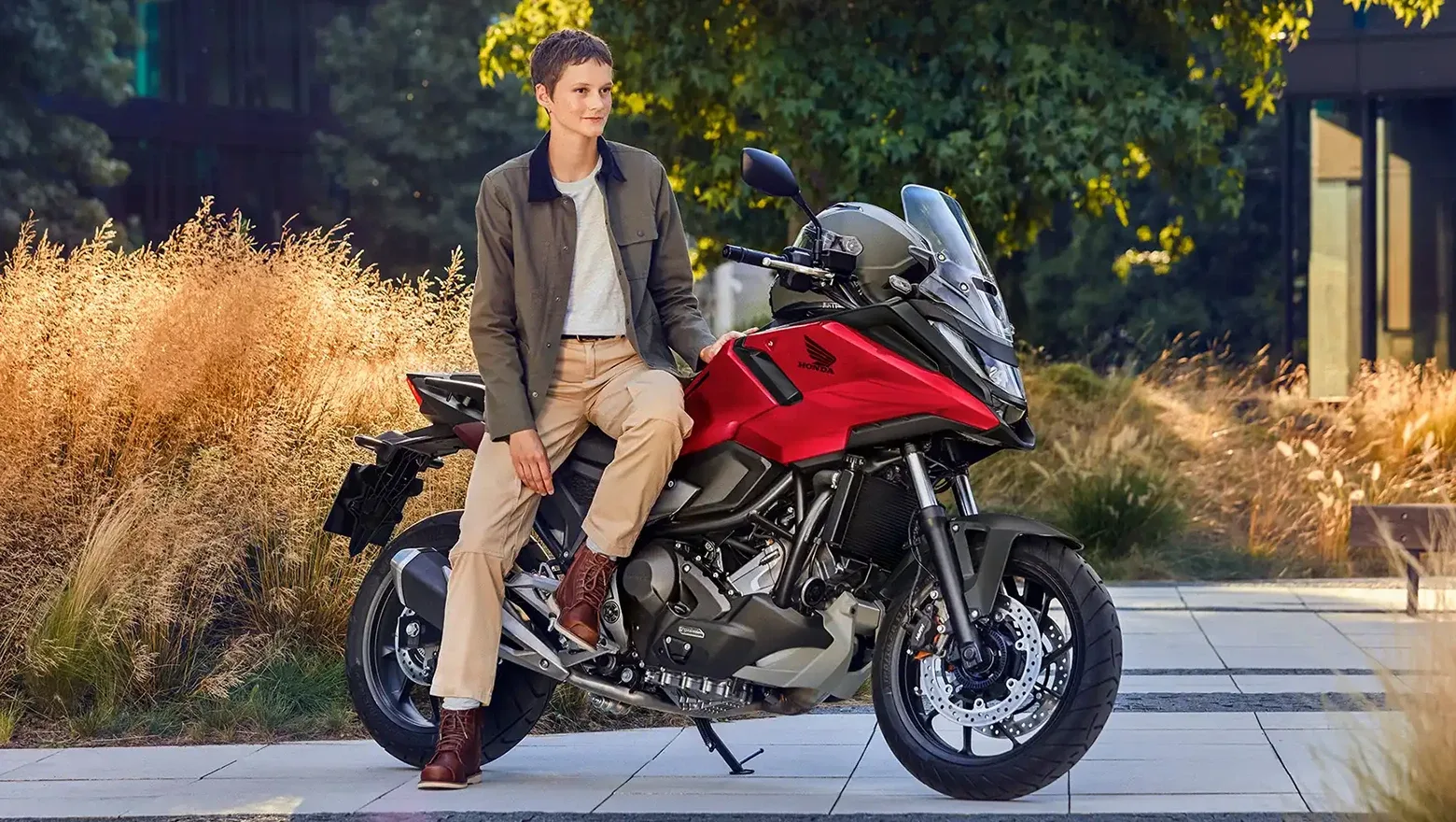Honda NC750X vermelha parada com piloto sentado