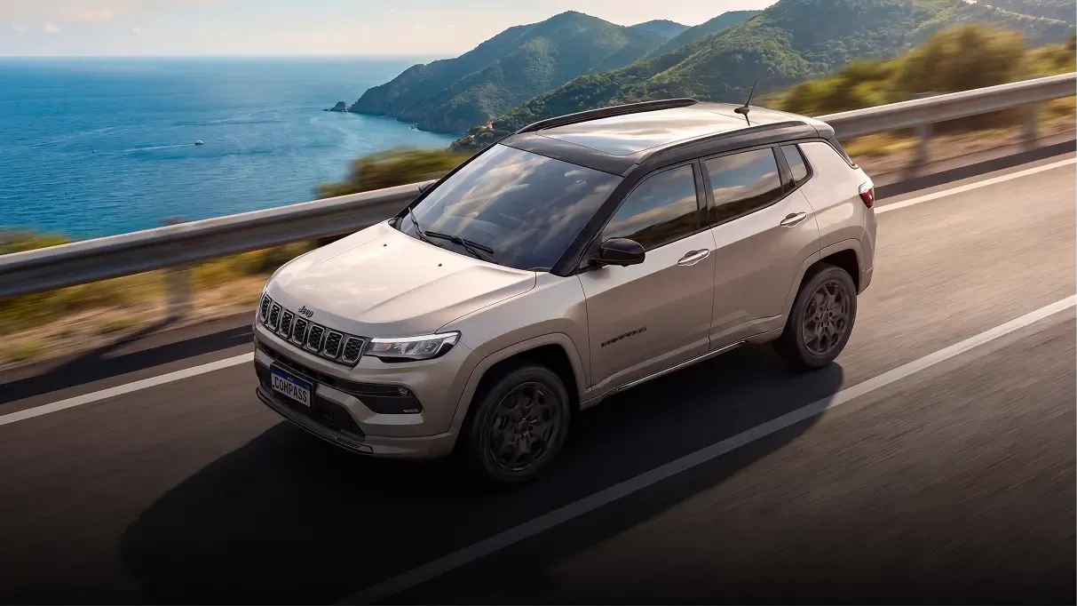 Jeep Compass 2027 branco em estrada à beira-mar