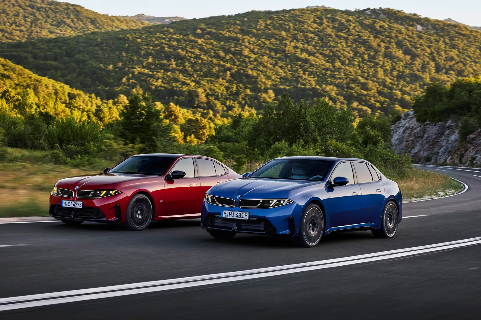 BMW M350 xDrive vermelho e BMW i3 elétrico azul lado a lado em uma estrada