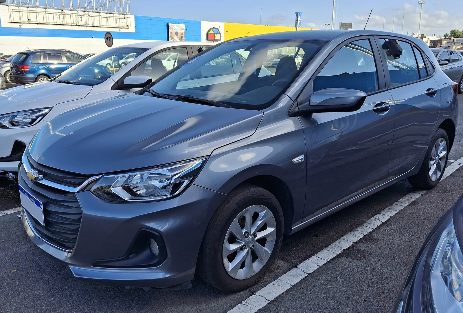 Chevrolet Onix hatch cinza estacionado