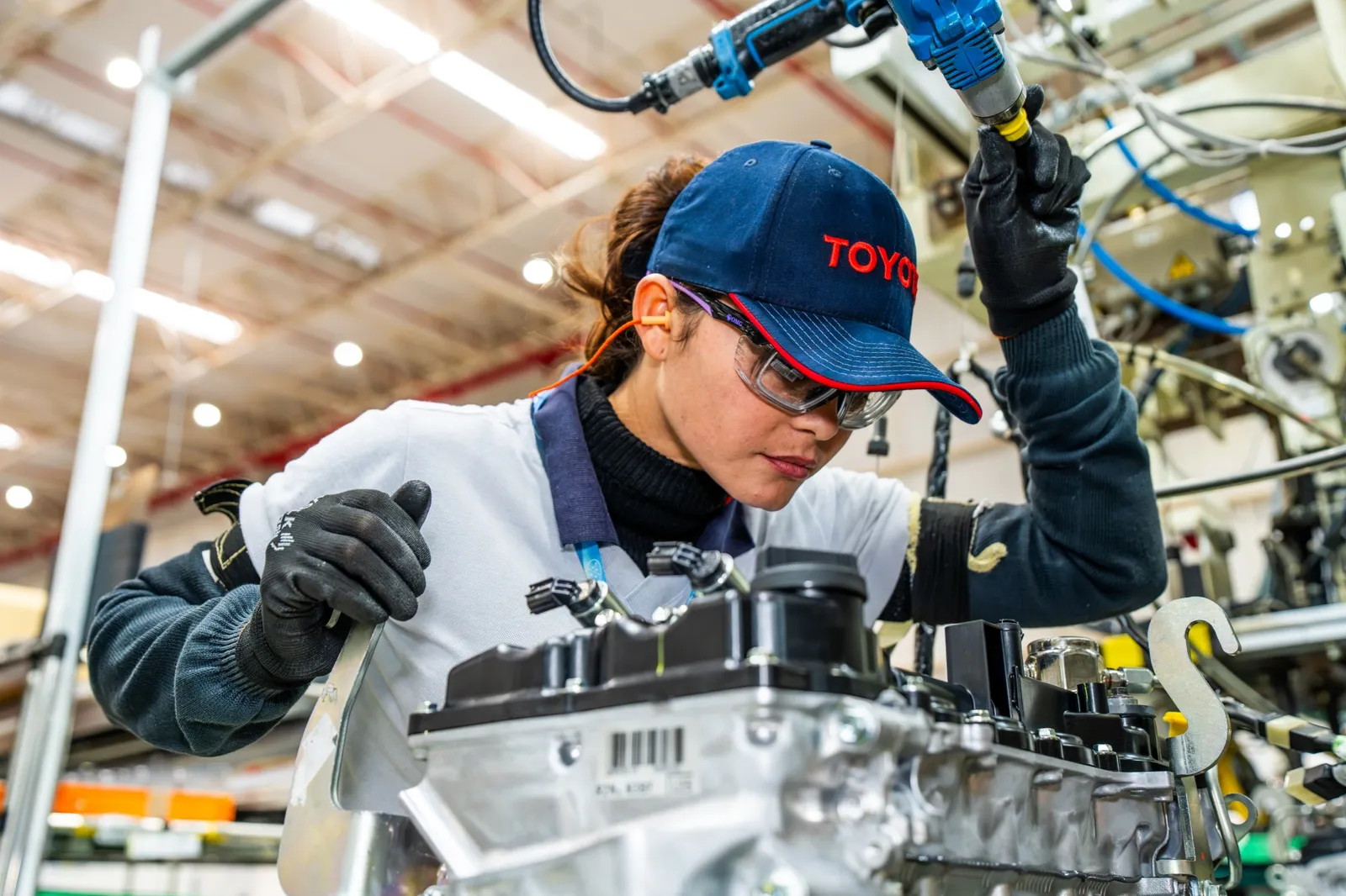 Funcionária da Toyota trabalha na montagem de um motor
